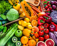 High angle view of a large assortment of healthy fresh rainbow colored organic fruits and vegetables. The composition includes cabbage, carrots, onion, tomatoes, raw potato, avocado, asparagus, eggplant, celery, cucumber, broccoli, squash, lettuce, spinach, lemon, apples, pear, strawberries, papaya, mango, banana, grape fruit, oranges, kiwi fruit among others. The composition is at the left of an horizontal frame leaving useful copy space for text and/or logo at the right. High resolution 42Mp studio digital capture taken with SONY A7rII and Zeiss Batis 40mm F2.0 CF lens